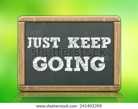JUST KEEP GOING - motivational concept written on blackboard