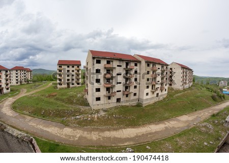 Abandoned blocks of flats under construction. Brick and cement textures with grass around it. Fish eye lens effect