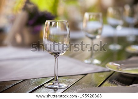 Moody ornamental arrangement with glasses with blue flowers in the background and wooden table