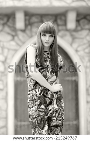 Black and white photo of a beautiful, caucasian, young, long haired woman posing in urban locations with natural background