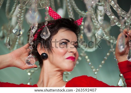 Photo session of an expressive,short haired, brunette woman with pieces of a cristal chandelier