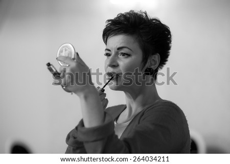 Photo session of an expressive,short haired, brunette woman during the make up session. Black and white photography