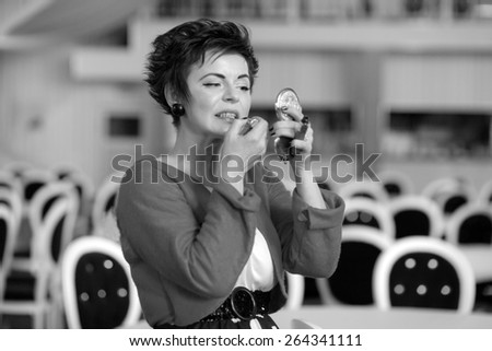 Photo session of an expressive, short haired, brunette woman during the make up session. Black and white photography