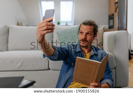 Similar – Image, Stock Photo Young man recording himself while playing guitar and singing to share the video in social media. Musician recording a music video at home.