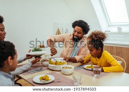 Bonding over lunch time. Afro family of four having lunch together at home ストックフォト © 