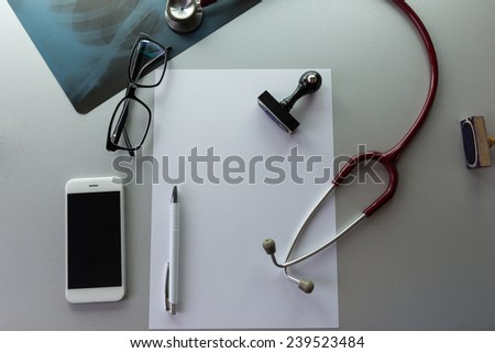 The Doctor\'s desk with the working equipment. Copy space on the white paper. Medical Concept