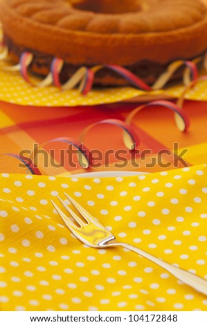 An summer party table setting with fork, napkin and dish.