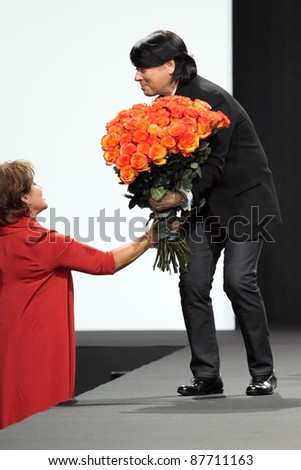 MOSCOW - OCTOBER 26: Fashion designer Valentine Yudashkin is presented flowers during a display of his  collection as part of Fashion Week on October 26, 2011 in Moscow, Russia