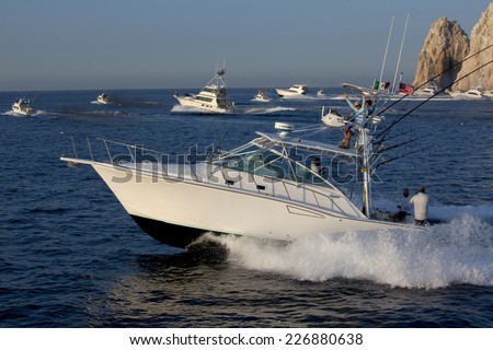 Cabo San Lucas, Mexico - Oct 24, 2014: Sport fishing boats taking off at the start of a fishing tournament in Cabo San Lucas with Land's End in the background in Cabo San Lucas, Mexico - Oct 24, 2014