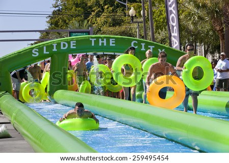 West Palm Beach, Florida, USA - Feb 14, 2015: Slide the City where 1000s of people enjoying a 5 block long water slide is set up on Clematis Street in downtown West Palm Beach, Florida on Feb 14, 2015