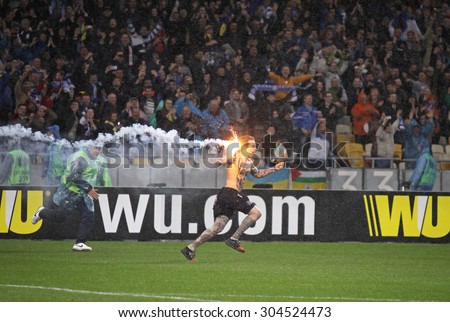 KYIV, UKRAINE - MAY 14, 2015: FC Dnipro ultra supporter runs out into the pitch with flare to celebrate victory after UEFA Europa League semifinal game against Napoli at NSK Olimpiyskyi stadium