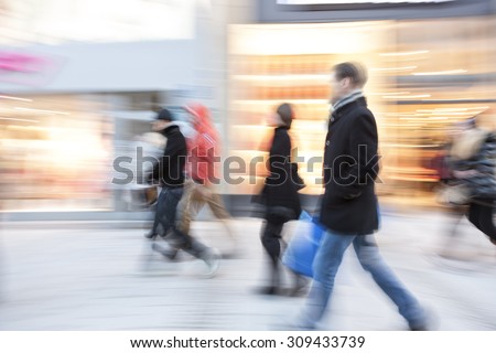 Young people walking down shopping street, motion blur