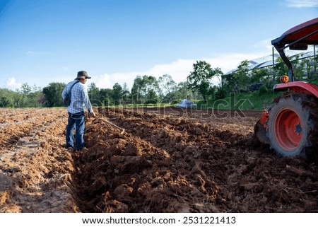 Similar – Image, Stock Photo Potato plantation and tractor farmer cultivating rows. Agroindustry and agribusiness. Cultivation of a young potato field. Loosening of the soil between the rows of bushes. Blurry