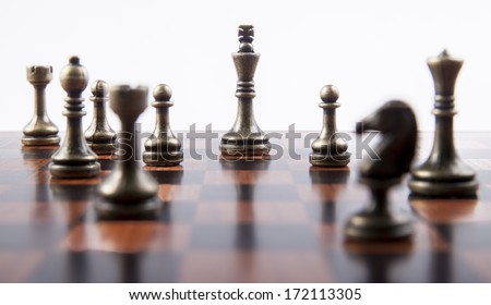 Bronze Chess Set on White Background with Wooden Chess Board, Focusing on King