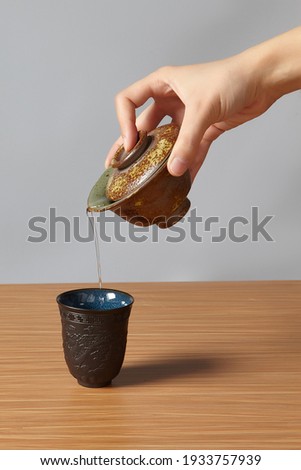 Similar – Image, Stock Photo Woman pouring green tea in mug on wooden table with green herb