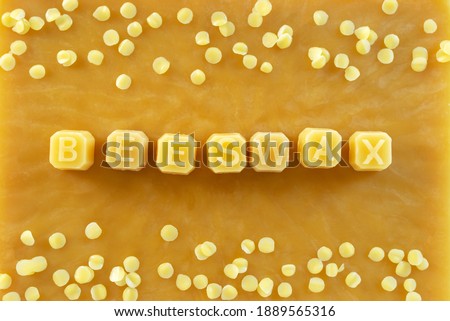 beeswax letters made from yellow natural beeswax on  beeswax texture background.