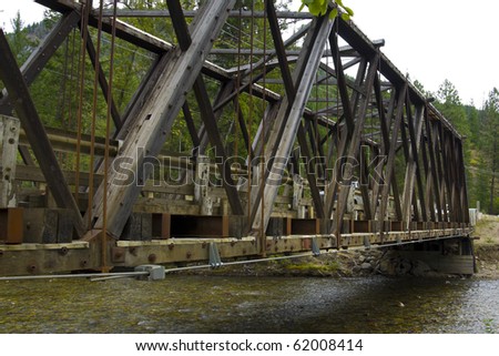 Old style wooden bridge over a shallow salmon filled river