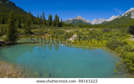 Rocky Mountains reflected in one of the ponds at the \