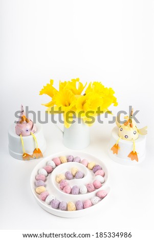 Easter scene with spring chickens and mini eggs in a spiral dish