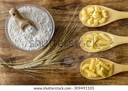 pasta, flour and wheat on wood