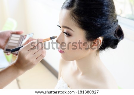Makeup artist having applied foundation makeup  a model/Wedding  Makeup artist