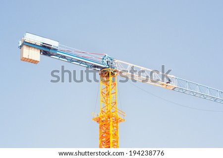 Crane at construction site against blue sky / Crane at construction site