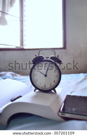 Alarm clock on book at home / Alarm clock