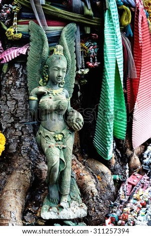 Broken Angel statue on Bodhi tree at the side of the road / Broken Angel statue