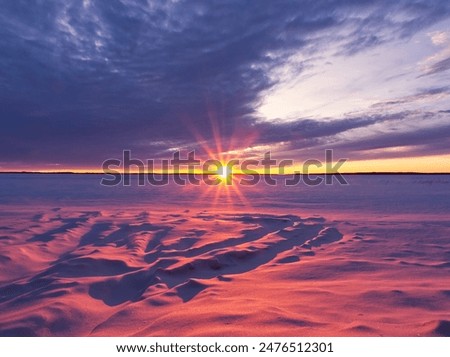 Similar – Image, Stock Photo Sunset over a frozen lake. Sunbeams falling on water. Shadows of trees on the ice covering the lake. Aerial view of a frozen lake. Ice sheet background. Frozen grass in water