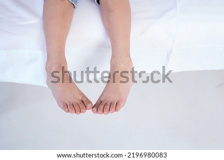 Image, Stock Photo Baby legs dangling from high chair; baby wearing turquoise outfit with bare feet against white wood background