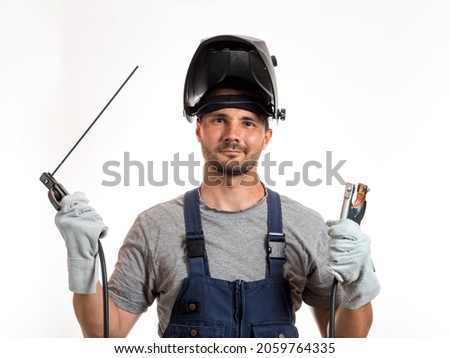 Similar – Image, Stock Photo A man welder with construction gloves and a welding mask hard work and welds with a welding machine metal in workshop, close up