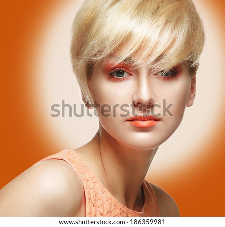 Beautiful Model Woman Face with orange makeup. Perfect Skin. Professional Make-up. Makeup. Fashion Art.