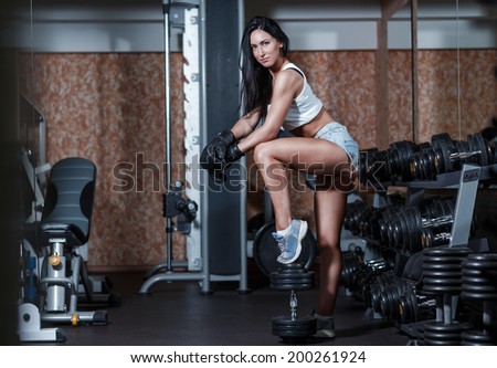 Sexy girl with boxing gloves posing in the gym