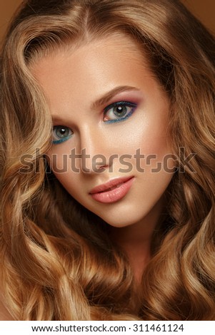 Beautiful Woman with Curly Long Hair. Color makeup.