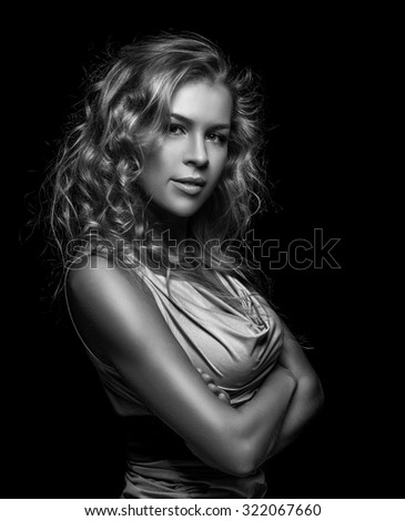 Glamorous portrait of a beautiful woman - crossed her arms. Long wavy hair. Black and white photo.
