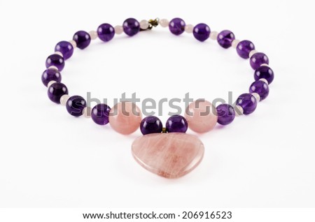 Amethyst necklace with rose quartz beads and heart shaped pendant on white background