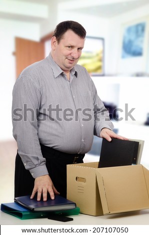 Overweight middle-aged man got new job in investment company. Man unpacking folders