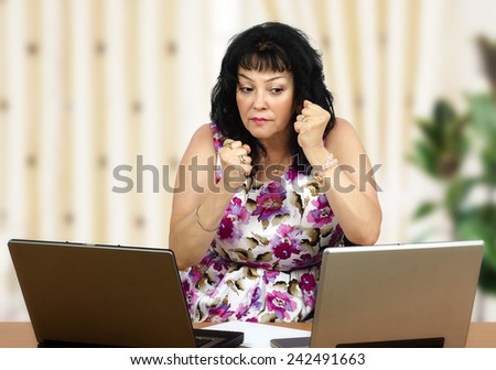 Irritated mature black-haired woman listening to someone on the internet