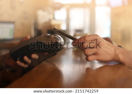 Similar – Image, Stock Photo Macro unknown hand giving terminal to visitor for mobile phone payment indoor. Client hand paying bill with smartphone in blurred background. Cropped shot hands making contactless transaction inside.