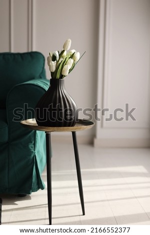 Similar – Image, Stock Photo artificial white tulips and green leaves in a black vase on the table in home interior.