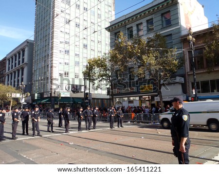 SAN FRANCISCO, CA - NOVEMBER 3: Police officers stand in line across market street at intersection during the World Series Parade as a Police van rolls by on Nov. 3, 2010 San Francisco, CA.