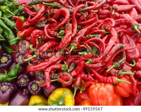 Mix of colors (red, green, purple, orange, and yellow) and types of Peppers at a farmers market in San Francisco.