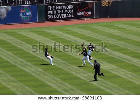 OAKLAND, CA - AUGUST 4: Royals vs. Athletics: Athletics run down ball in outfield with Mark Ellis opening glove to make catch. August 4 2010 at Coliseum Oakland California.