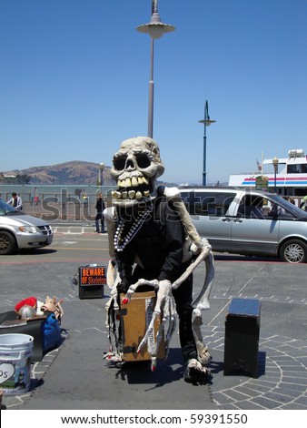 SAN FRANCISCO - JULY 28: Skeleton man hangs out on fisherman\'s wharf waiting for people wanting to take picture with him.  July 28, 2010 Fishermans Wharf, San Francisco California.