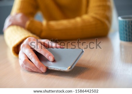 Woman Concerned About Excessive Use Of Social Media Laying Mobile Phone Down On Table Foto stock © 