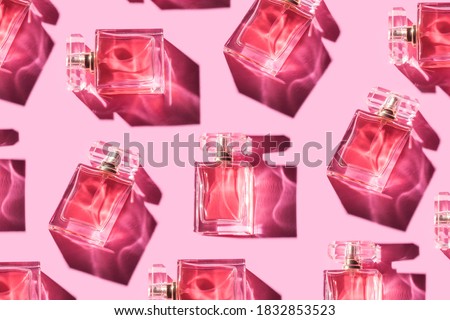 Pattern bottles of woman perfume on a pastel pink background, top view, flat lay. Mockup of pink fragrance perfume bottle mockup on pastel pink empty background