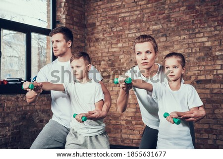 A man teaches his son self defense in a gym. Mom and daughter train with dumbbells while standing in the gym.  Foto stock © 