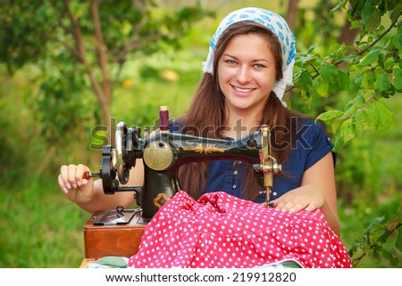 Smiling woman with a retro hand sewing machine