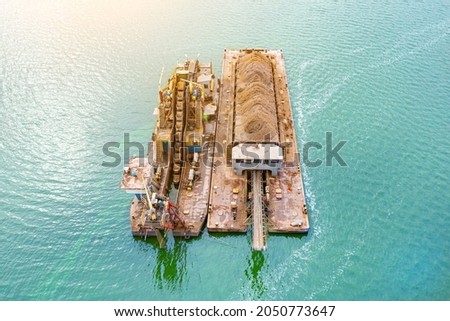 Extraction of sand from the river, excavator digs out sand from the bottom of the lake and unloads it on a floating barge, mining Zdjęcia stock © 