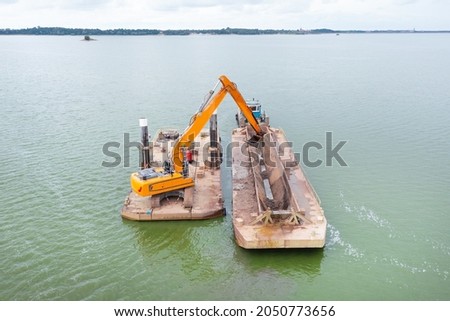 Extraction of sand from the river, excavator digs out sand from the bottom of the lake and unloads it on a floating barge, mining Zdjęcia stock © 